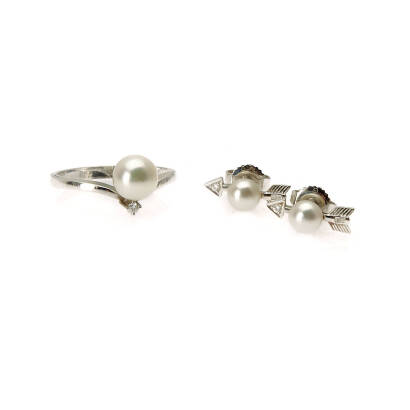 An Akoya pearl ring and earrings, Mikimoto. The ring comprises of one 7mm Akoya pearl and accented with one round brilliant cut diamond of estimated weight 0.02 carat. The earrings comprise of two Akoya pearls set in arrow design and accented with diamond