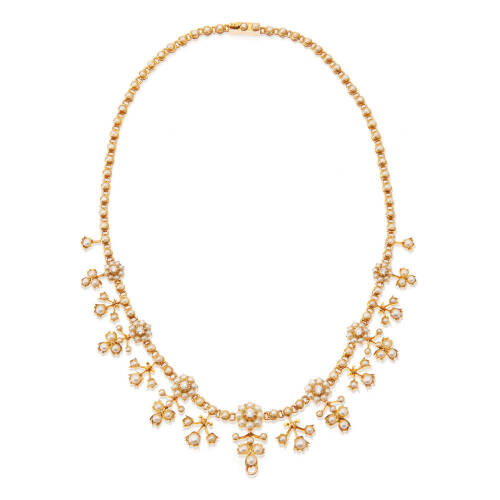 An Edwardian 'Belle epoque' diamond and seed pearl necklace, circa 1895-1910. Comprised of flower motifs, seven claw set early round brilliant cut diamonds of estimated total weight 0.81 carats, surrounded and accented with 176 seed pearls. 14/15ct yellow