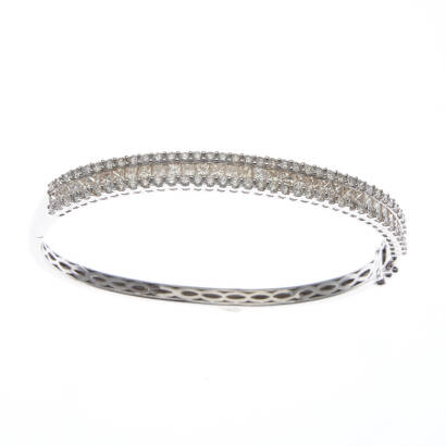 A triple row diamond bangle, front section of the hinged bangle consists of a central row of thirty-three channel set princess cut diamonds of estimated total weight 2.43 carats, accented on either side by seventy-four round brilliant diamonds of estimate