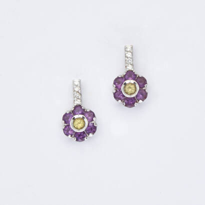 A pair of amethyst, peridot and diamond earrings, Pasquale Bruni. Two bezel set round cut peridot centres surrounded by twelve round cut amethysts and accented with eight round brilliant cut diamonds. 18ct white gold. Weight 2.9 grams. Length 13mm.