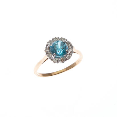 A blue zircon and diamond cluster ring, claw set round brilliant cut zircon centre, surrounded by ten single cut diamonds. 18ct yellow gold and platinum. Weight 2.3 grams. Ring size M1/2.