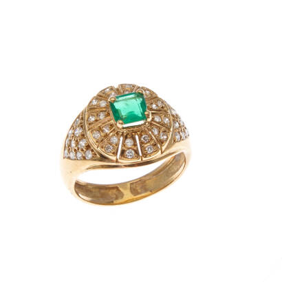 An emerald and diamond dress ring, claw set emerald cut emerald of estimated weight 0.57 carat, surrounded by forty-four bead set single cut diamonds of estimated total weight 0.52 carats. 18ct yellow gold. Weight 5.9 grams. Ring size N1/2. Gemologist's r