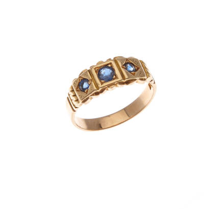 A sapphire ring, circa 1900. Three bead set round mixed cut sapphires in engraved band. 15ct yellow gold. Weight 3.7 grams. Size M 1/2.
