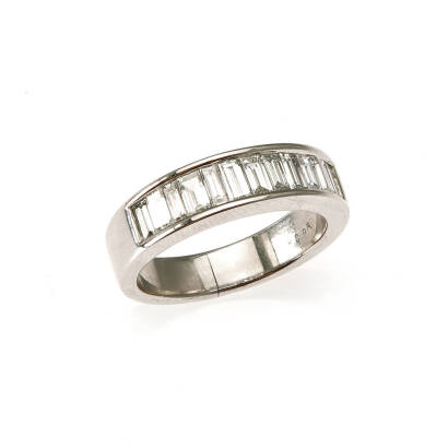 A diamond band style ring, a row of twelve channel set baguette cut diamonds of estimated total weight 0.95 carats. 18ct white gold. Weight 6.0 grams. Ring size L. Gemologist's report available.