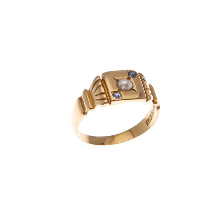 A seed pearl and sapphire ring, circa 1890-1910, gypsy set seed pearl centre, with an old cut sapphire each side on square plaque. 18ct yellow gold. Weight 3.9 grams. Ring size M1/2. Birmingham hallmarks.