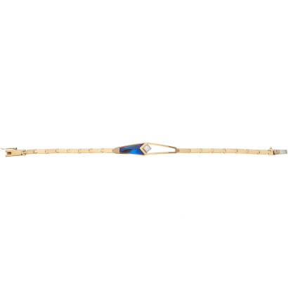 A gold and diamond bracelet, bezel set princess cut diamond centre, accented with blue oxidised panel. 18ct yellow and white gold. Weight 22.5 grams. Length 20cm.