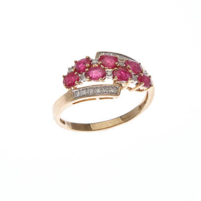 A ruby and diamond ring, seven claw set oval cut rubies, accented by nineteen round brilliant cut diamonds of estimated total weight 0.12 carats. 9ct yellow gold. Weight 2.9 grams. Ring size T1/2