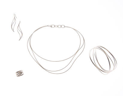 A suite of Wave by Elsa Peretti, Tiffany & Co. The suite comprises of necklace, bangle, drop earrings and ring. 18ct white gold. Necklace inside diameter 13.8cm. Bangle inside diameter 7cm. Earrings length 65mm. Ring size M. One original suede box.