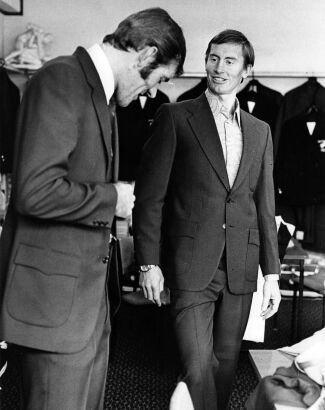 New Zealand coxed four stroke Warren Cole models a modern travelling suit for teammate Athol Earle, 1972