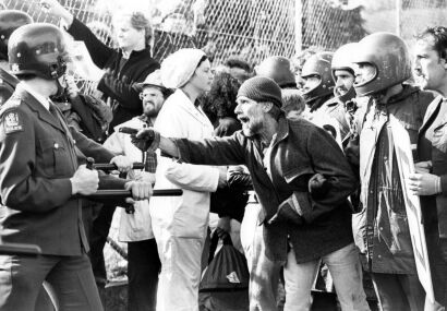 Protesters and police officers dressed in riot gear during a demonstration outside Eden Park