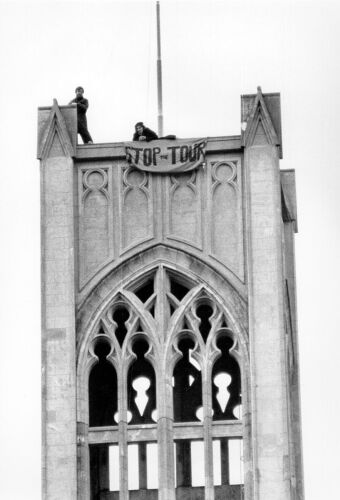 Protesters display "Stop The Tour" banner from top of building