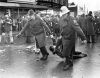 Two police officers drag a protestor down the street during a demonstration