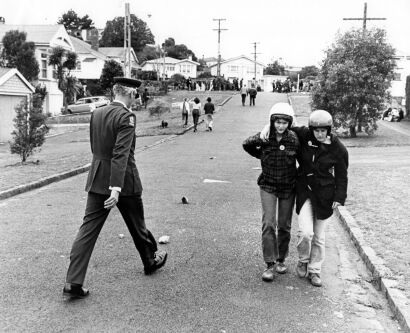 As injured demonstrators leave the clash, Inspector Brian Davies, head of Operation Rugby, makes his way toward the confrontation at Eden Park