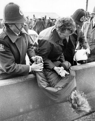 An arrested protester is held over the motorway centre wall while police wait for more transport