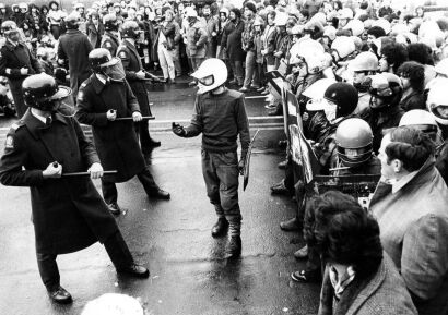 Riot squad members and a protest marshal exchange looks during a confrontation at the southern end of Adelaide Road