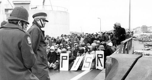 A small group of protesters sit it out with the police during a non-violent demonstration on the Aotea Quay overbridge