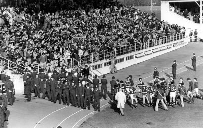 Players from both teams exit the field as police officers and spectators look on