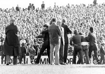 Inspector Brian Davies stands with protesters and police gathered on the field