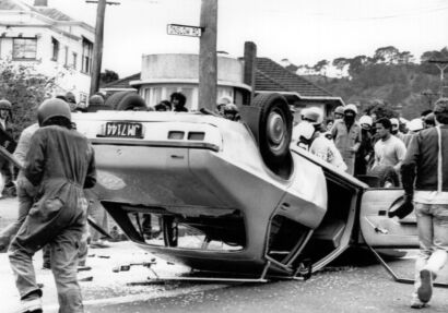 Rioters overturn a police car during anti-tour demonstration outside Eden Park