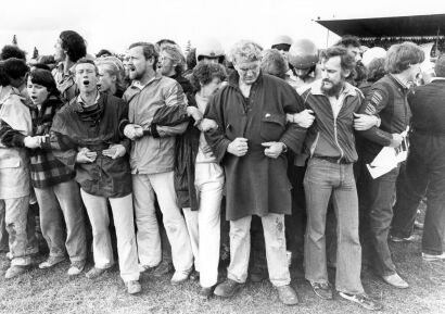 Protesters join arms and shout their defiance from the centre of the field at Rugby Park, Hamilton