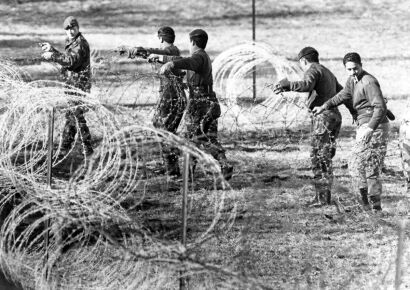 Members of the army place barbed wire around the rugby grounds