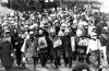 Anti-tour protestors outfitted in riot gear as they march the streets