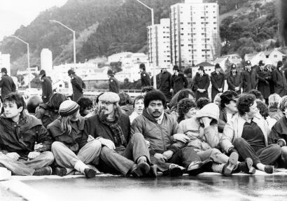 A small group of protesters sit it out with the police during a non-violent demonstration on the Hutt Motorway