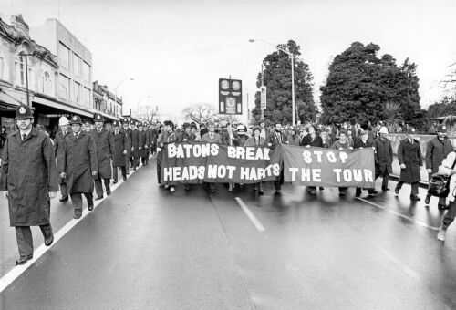 Anti-tour protesters, flanked by police, peacefully march in the streets