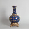 A Chinese Blue-ground Gilt-decorated 'Butterfly' Bottle Vase with bronze base (Da Qing Guangxu Nian Zhi Mark)