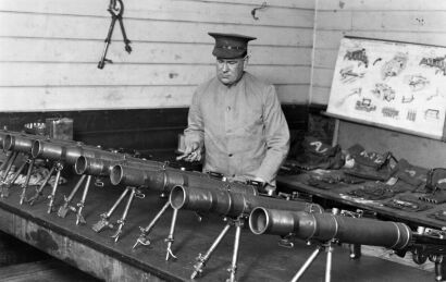 ARMOURER INSPECTING GUNS AT KING EDWARD BARRACKS