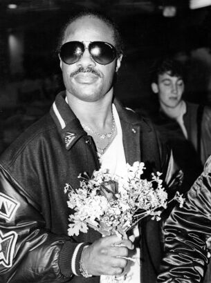 Stevie Wonder receives flowers upon arrival in Auckland