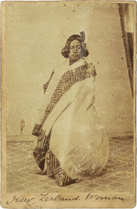 AMERICAN PHOTOGRAPHIC COMPANY, AUCKLAND Seated Māori woman with Huia feather in her hair and Kaitaka aronui with taniko border