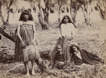 C. P. COTTIER, NEW PLYMOUTH Photograph of three Māori women, one dressed in two layers of piupiu, others Victorian dress and white feathers, and a boy. Ngā Māhanga iwi