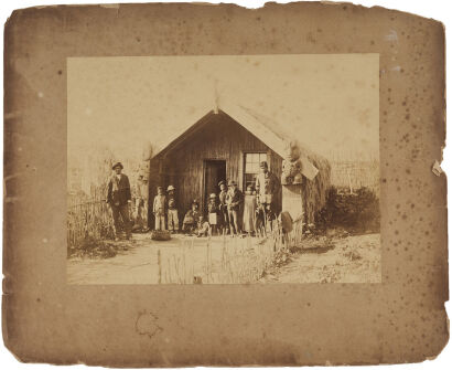 F. A. COXHEAD, DUNEDIN Ngāti Whakaue whare, Ohinemutu - Māori couple with 8 children in front of whare with garden