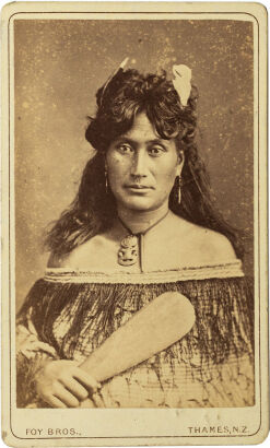 FOY BROS, THAMES Portrait of Māori woman with two Huia feathers, hei tiki, Korowai cloak and mere