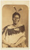 FOY BROS, THAMES Portrait of Māori man with moko, two Huia tail feathers, wearing a Kaitaka aronui with taniko border, heitiki and holding a patu