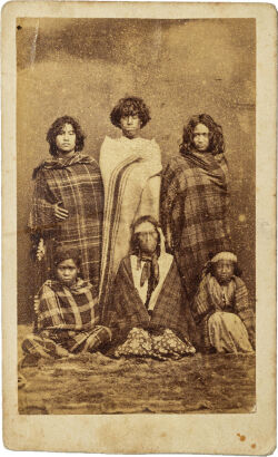 UNKNOWN PHOTOGRAPHER Māori group with woman, three youths and two children wrapped in tartan and blankets