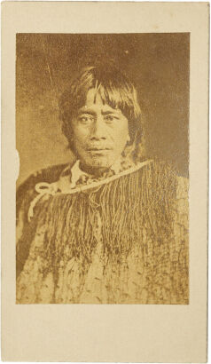 UNKNOWN PHOTOGRAPHER Portrait of a Māori woman with moko kauae, European collared shirt and korowai