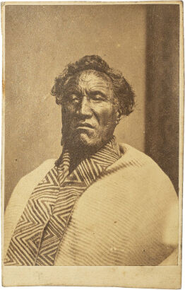 UNKNOWN PHOTOGRAPHER Portrait of a Māori man with moko, ribbon earring and Kaitaka aronui