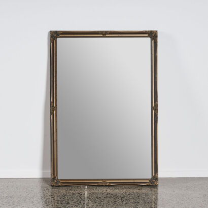 An Antique Style Mirror With Detailed Frame