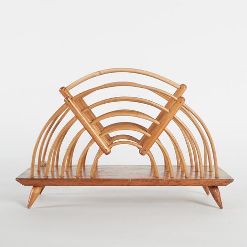 A Bent Cane Magazine Rack With An Oak Base