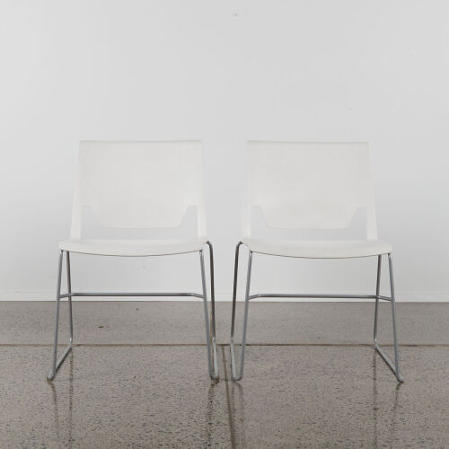 A Pair of Modern White Chairs With Steel Sleigh Base