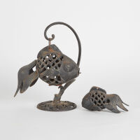 Two Japanese Iron 'Fish' Candlesticks