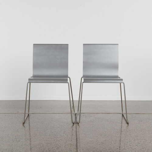 A Pair Of Folded Metal Chairs With Sleigh Bases