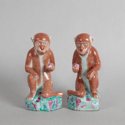 A Pair of Chinese Late Qing Dynasty (Late 19th to Early 20th Century) Famille Rose Seated Monkeys Each one Holding a Peach(old repair to one foot)