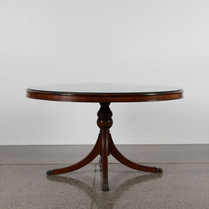 A Circular Mahogany Table With A Glass Overlay