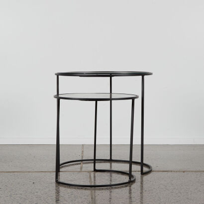 A Pair Of Black Metal Nesting Tables With Marbled Mirrored Tops