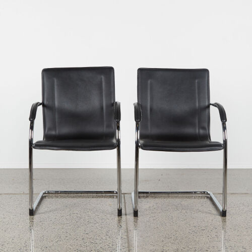 A Pair Of Black And Chrome Chairs