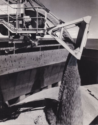 WOLFGANG SIEVERS Bauxite pouring into a ship's hold at Weipa, Queensland