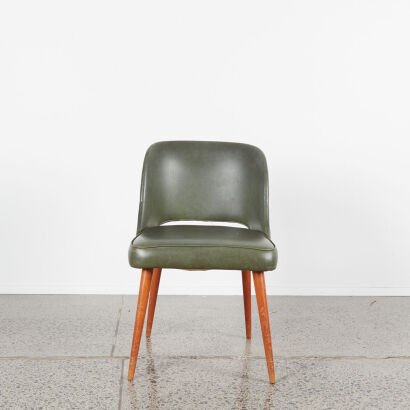 A Single Retro Chair In Green Upholstery